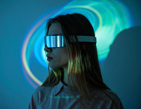 Futuristic woman in virtual reality glasses surrounded by swirling light, abstract immersive technology experience 