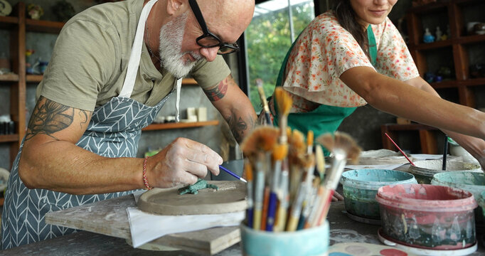 A happy couple makes ceramic plates in a workshop