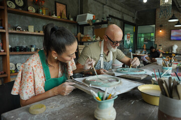 A happy couple makes ceramic plates in a workshop