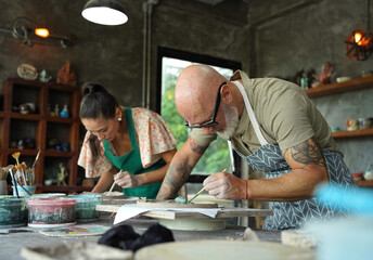 A happy couple makes ceramic plates in a workshop