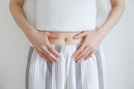 お腹を押さえる女性の腹部　ダイエット