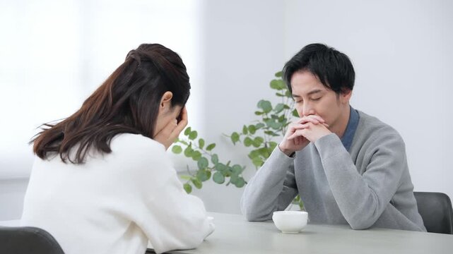 部屋で落ち込む男女カップル