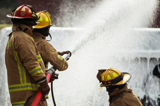Firefighters spraying water to control fire during emergency training