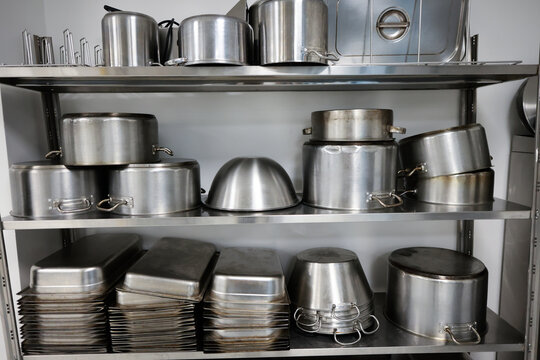 Details with stainless steel kitchen pots, pans and utensils in a professional canteen or hospital kitchen