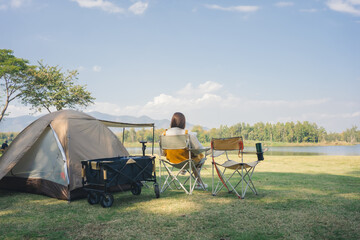 asian couple fun happy and relax with camping and picnic at side of lake with mountain background