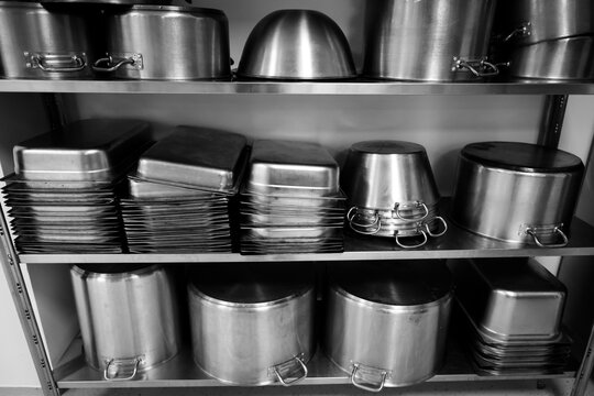 Details with stainless steel kitchen pots, pans and utensils in a professional canteen or hospital kitchen