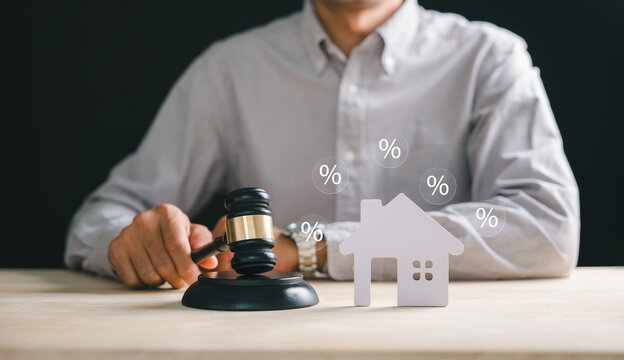 Man holding gavel symbolizes house foreclosure and bankruptcy concept, legal property auction sale, mortgage debt division, court judge decision with percentage icons showing high interest