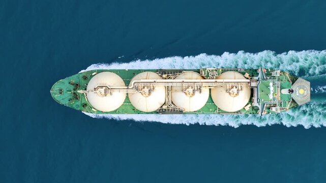 LNG tanker ship sailing in the open ocean. Liquefied Natural Gas carrier vessel with white spherical tanks transporting energy fuel. freight transportation shipping Global gas supply logistics.