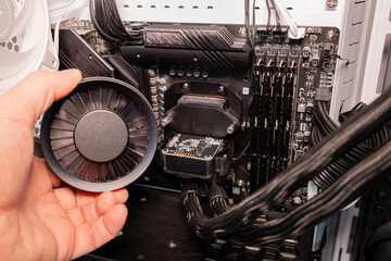 Close up of human hand holding a black plastic computer cooling fan for PC maintenance