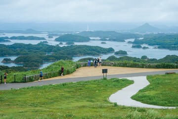 Tourists take pictures of the landscape at a scenic overlook of Saikai National Park's Kujukushima Islands, also called the 99 Islands, in Sasebo, Nagasaki Prefecture, Japan 