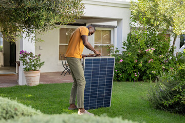 Naklejka premium Solar panel is standing upright on lawn by porch, with potted plant and patio table