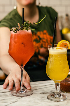 Colorful craft cocktails served at bar with citrus garnish and herbs