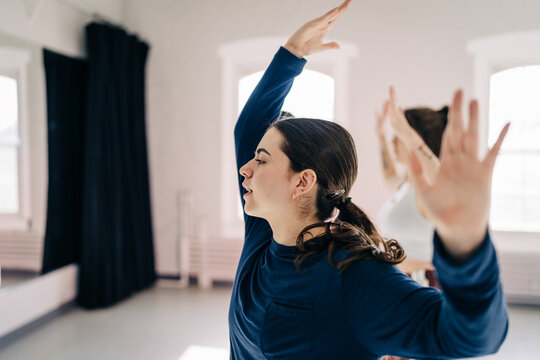 Woman practicing expressive dance movement in studio