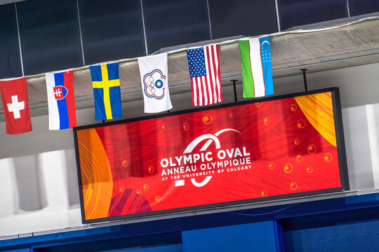 Calgary, Alberta, Canada. Jan 25, 2026. The Olympic Oval scoreboard and international flags at the University of Calgary speed skating facility.