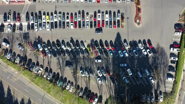 4K aerial drone footage of a busy car dealership parking lot in Beaverton, Oregon, with rows of electric vehicles and auto inventory, showing transportation, retail business, and urban infrastructure