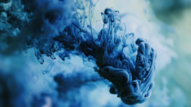 Deep blue ink swirling and dissolving in clear water, creating abstract patterns