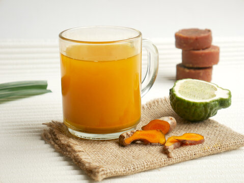 Turmeric health drink with lime, served in a clear glass.