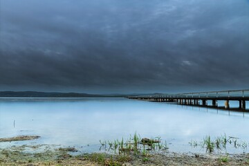 Obraz premium Rainy day sunrise waterscape with wharf