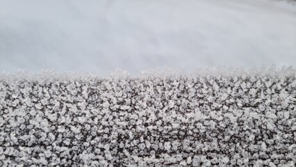 Snow covers ground and creates a white layer with small shapes in winter season