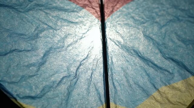 Close Up Macro Shot of Textured Paper Kite Surface Illuminated by Sunlight