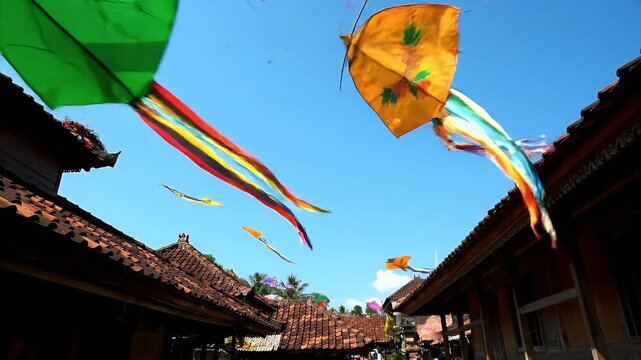 Colorful Kites Soar Against a Clear Blue Sky Above Traditional Buildings