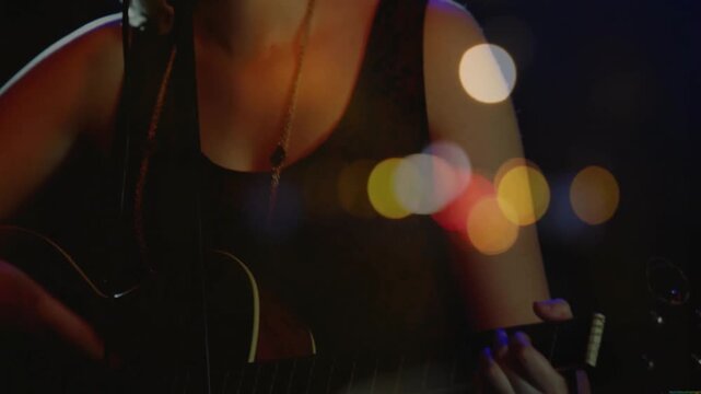 Teenage female singer singing into mic, featuring guitar neck and bokeh lights for music industry