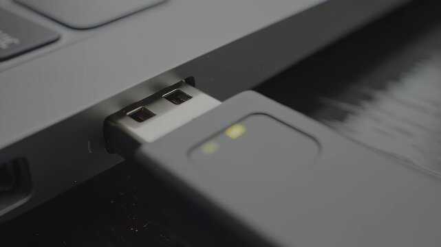 USB flash drive being inserted into a laptop port, showcasing the connection process with close-up details of the device and surrounding technology elements, hdr video with neutral color