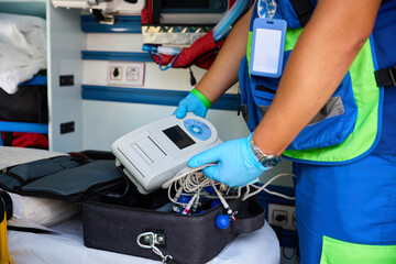Paramedic taking medical device from bag inside ambulance © Svitlana