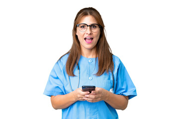 Middle age nurse woman over isolated background surprised and sending a message