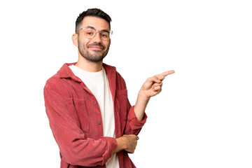Young handsome caucasian man over isolated chroma key background pointing finger to the side
