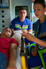 Medical team responding to female patient emergency in ambulance