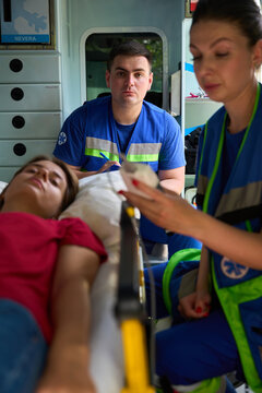 Medical team responding to female patient emergency in ambulance