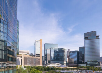 Fototapeta premium 青空を背景に様々なデザインのビルが建ち並ぶ都会の景観