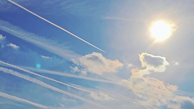 Commercial Jet Airplane Cruising at High Altitude in a Big Blue Sky With Clouds Making Contrails and Patterns in the Atmosphere, Airways, Air Travel, Sun Flair, No Audio, 19:6, Still Shot, 60fps - 1