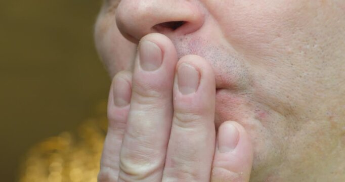 Close-up of a man examining his mouth, his teeth are crooked.