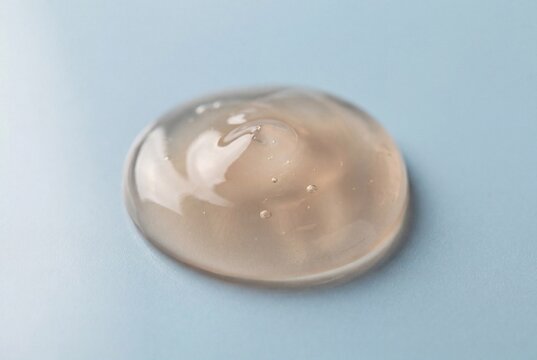Transparent beige cosmetic gel texture on a blue background