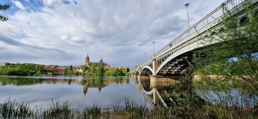Vista panor&aacute;mica de la Catedral Nueva y Vieja de Salamanca reflejada en las aguas tranquilas del r&iacute;o Tormes al atardecer, Espa&ntilde;a