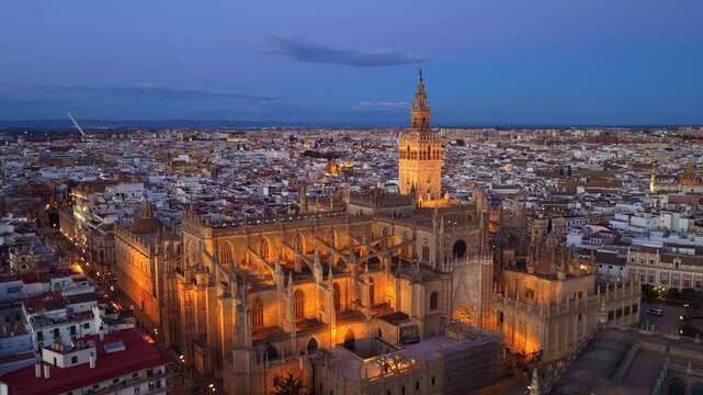 evening in Seville, aerial establishing shot of Seville gothic cathedral with famous Giralda bell tower. Travel in Seville, Spain.