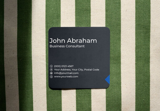 Mockup from real photo of square Business Card on a green and beige striped background.