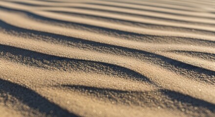 Fototapeta premium Close-up of Sand Dunes Textures showing undulating patterns and shadows under sunlight. The smooth curves and contrasting light create a sense of movement and tranquility