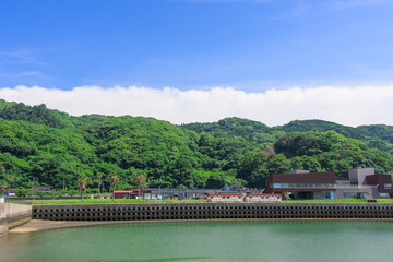 Fototapeta premium 青空を背景に 「潮風が運ぶ、防波堤から見える物産館周辺風景」 宇土市観光スポット(宇土マリーナおこしき館) With a blue sky as a backdrop 