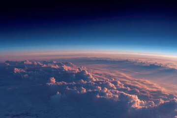 Stunning panoramic aerial view of vibrant clouds illuminated by warm sunset light beneath a deep blue sky creating a serene and breathtaking horizon scene