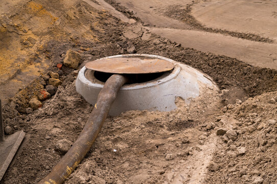 Septic tank pumping hose in ground during maintenance