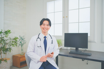 明るく清潔感のあるクリニックで診察をする若い男性医師
