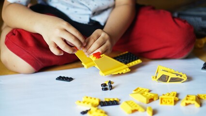 Close up of child's hands playing with colorful plastic bricks or lego. Toddler having fun and building out of bright constructor bricks. Development toys © Hai.. Zainul
