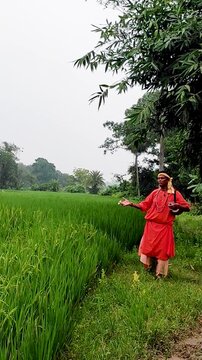 A serene folk singer, dressed in an orange robe, walks alone along the village road, singing with a string instrument&mdash;a peaceful portrait of devotion, tradition, and spiritual calm in rural India.