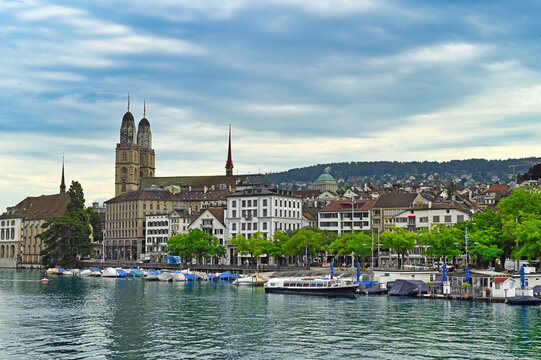 Historic Zurich city center with famous Grossmunster churh and boats on the river Limmat