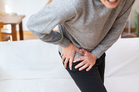 足の付け根を抑える男性