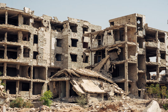 Collapsed and heavily damaged apartment buildings in Jobar, Damascus, showing destruction from the Syrian Civil War.