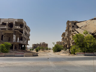 Devastated urban scene in Jobar, Damascus, with destroyed structures and deserted roads after the conflict.